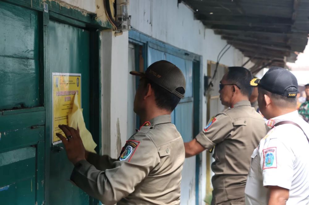 Petugas Satpol PP menutup usaha puluhan warung yang berada di Pasar Janti Ponorogo, Senin (12/5/2025).