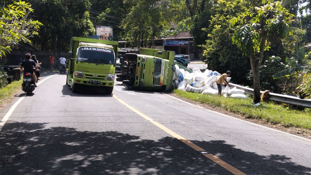 Sebuah truk bermuatan dedak terguling di jalur Amlapura menuju Denpasar, tepatnya di wilayah Banjar Dinas Tengading, Desa Antiga, Kecamatan Manggis, Karangasem, Senin (30/6/2025).