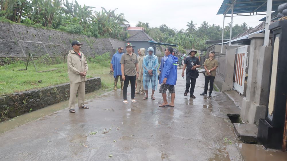 Bupati Jembrana I Made Kembang Hartawan saat meninjau korban banjir di salah satu perumahan di Kelurahan Baler Bale Agung, Minggu (6/7/2025).