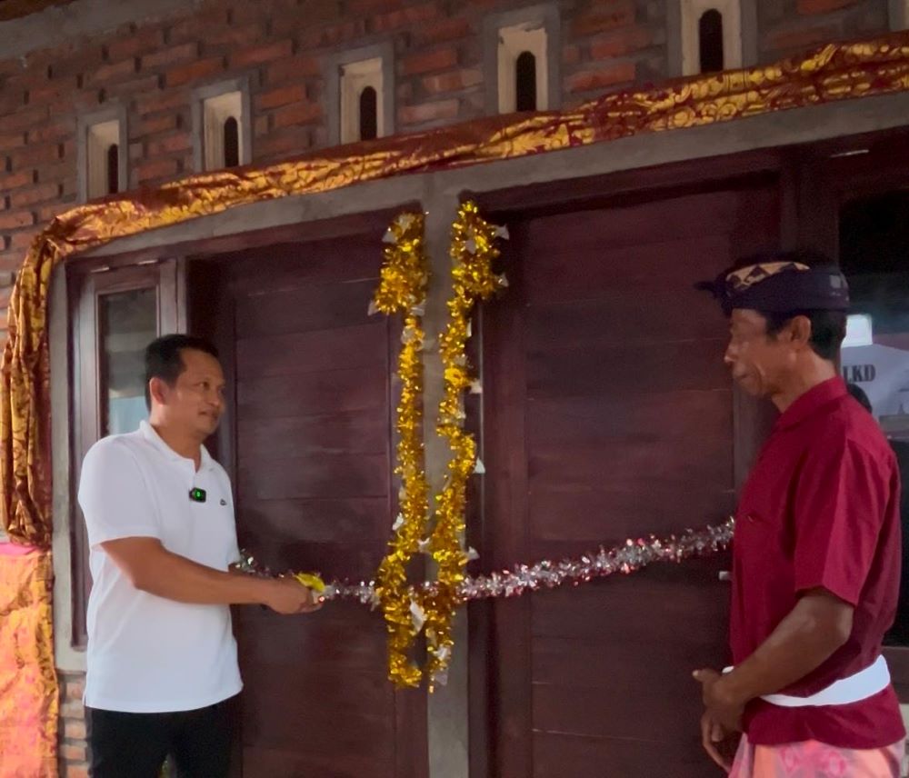 Bupati Jembrana I Made Kembang Hartawan menyerahkan kunci program bedah rumah bantuan kerjasama Bumdes Bersama dan LKD Kecamatan Negara, Selasa (19/8/2025).
