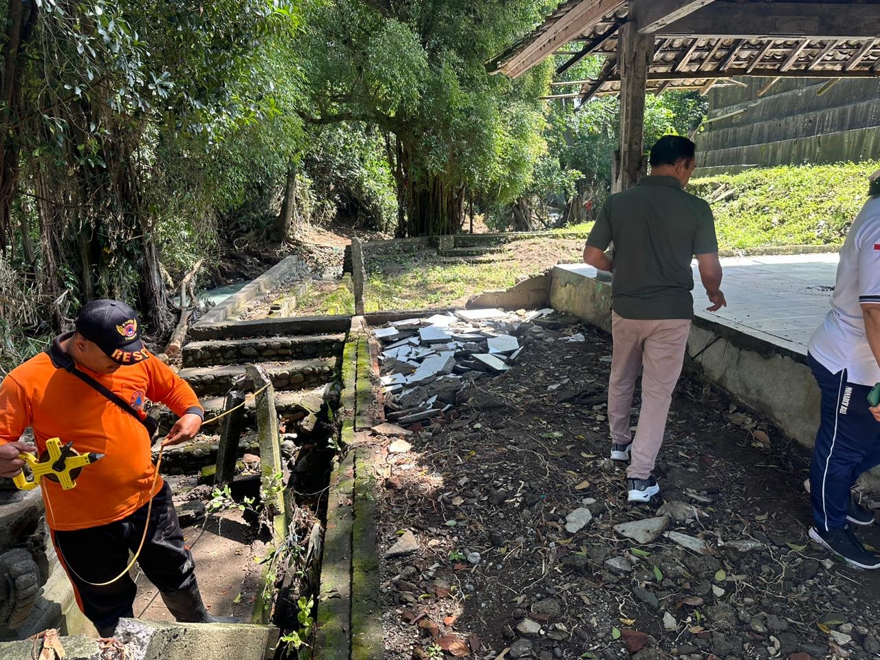Petugas BPBD Jembrana lakukan pengecekan kondisi pura Taman Beji, Kelurahan Pendem, Kecamatan Jembrana pasca banjir.