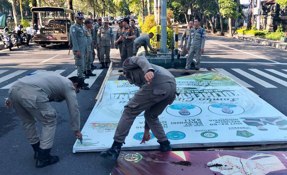 Petugas Satpol PP Jembrana melakukan penertiban reklame kadaluarsa dan rusak di wilayah Kecamatan Jembrana, Selasa (14/10).