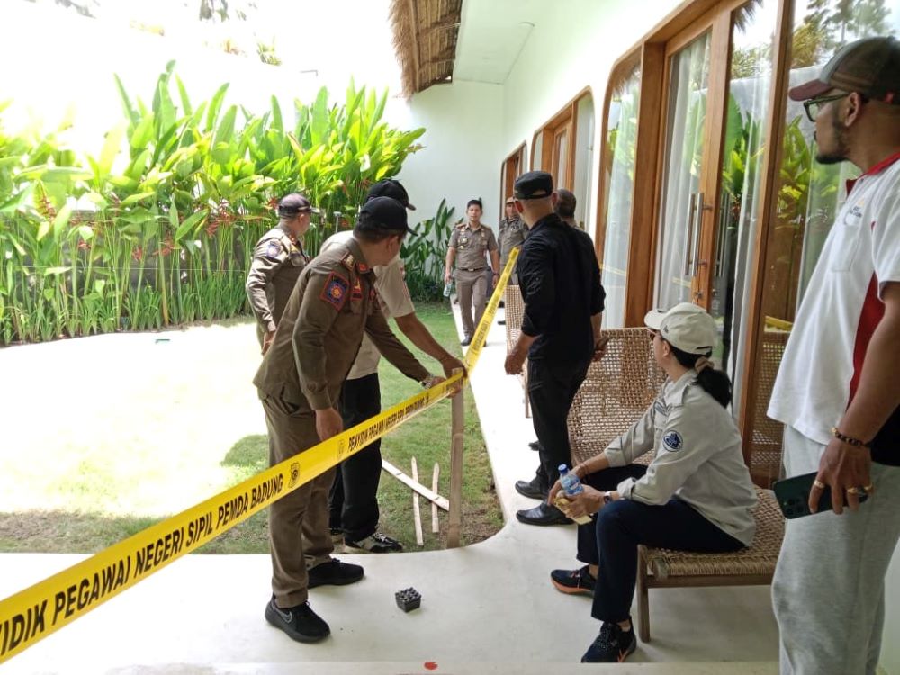 Satpol PP Badung memasang Pol PP Line di salah satu bangunan vila yang melanggar di Desa Canggu, Kuta Utara, Selasa (28/10/2025).