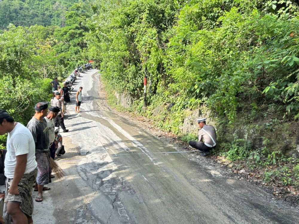 Polantas melakukan olah TKP kecelakaan lalu lintas yang menewaskan seorang pengendara motor di Nusa Penida.