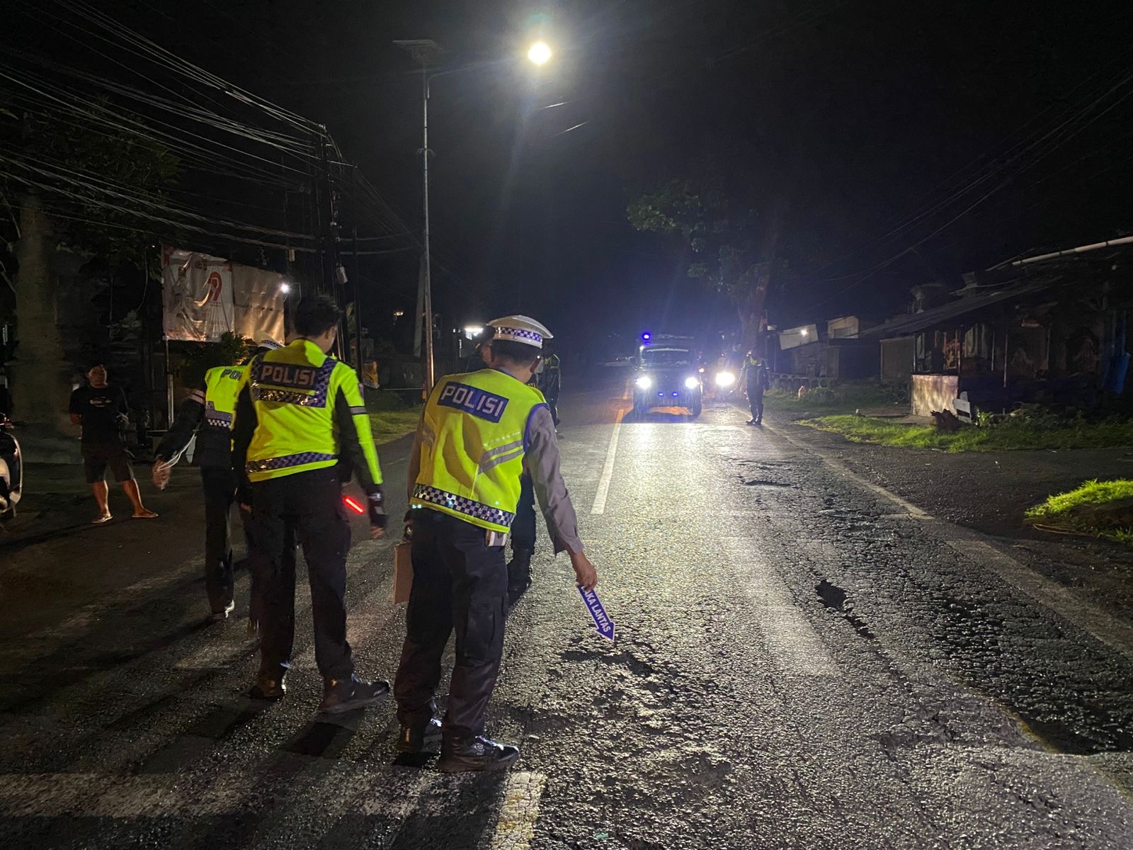 Petugas kepolisian melaksanakan olah TKP laka lantas di depan Polsek Mendoyo, Jembrana.