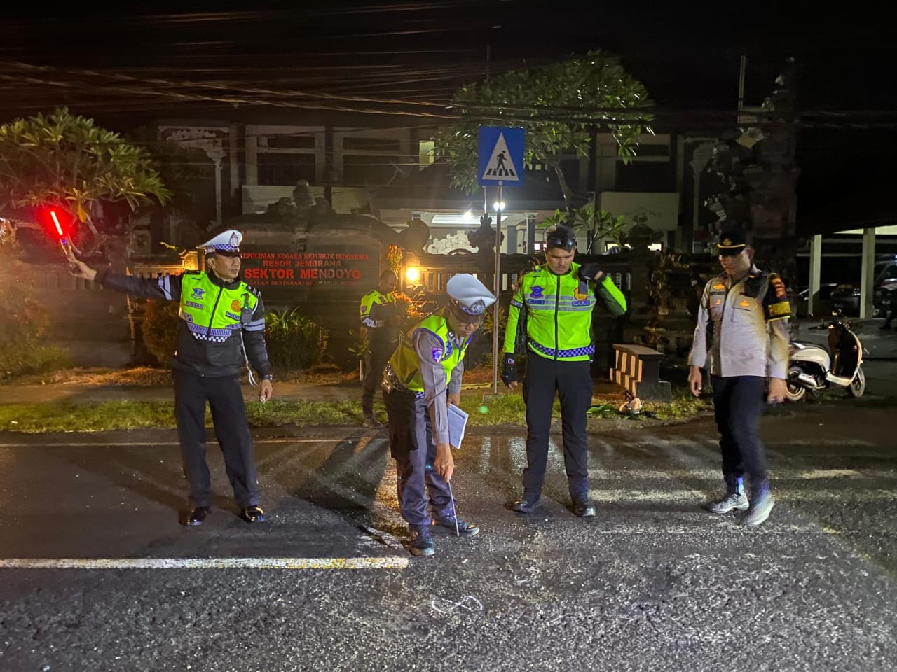 Petugas kepolisian melaksanakan olah TKP laka lantas di depan Polsek Mendoyo, Jembrana.