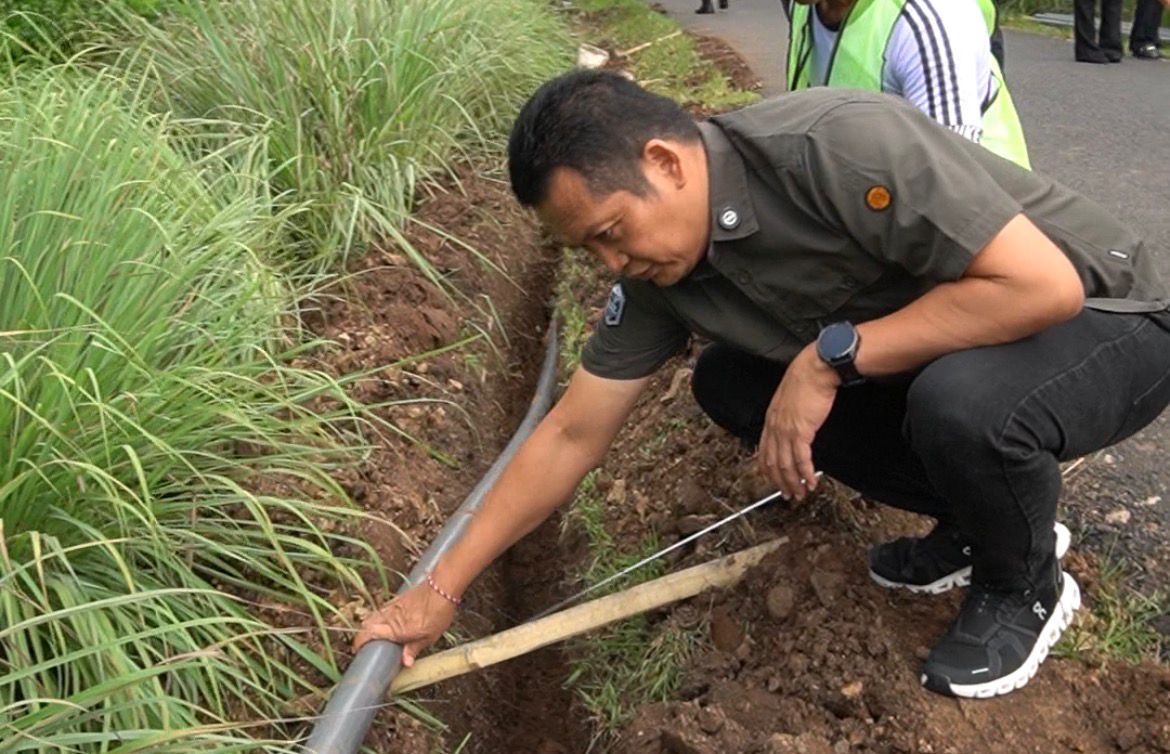 Kembang Hartawan saat turun melakukan pengecekan pemasangan jaringan air bersih untuk warga Banjar Sari Kuning, Selasa (6/1/2026).