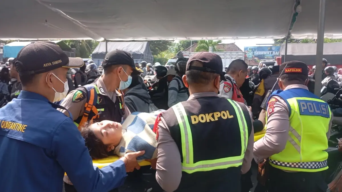 Tim Dokes Polres Jembrana saat menolong pemudik yang pingsan di Gilimanuk, Minggu (15/3/2026).