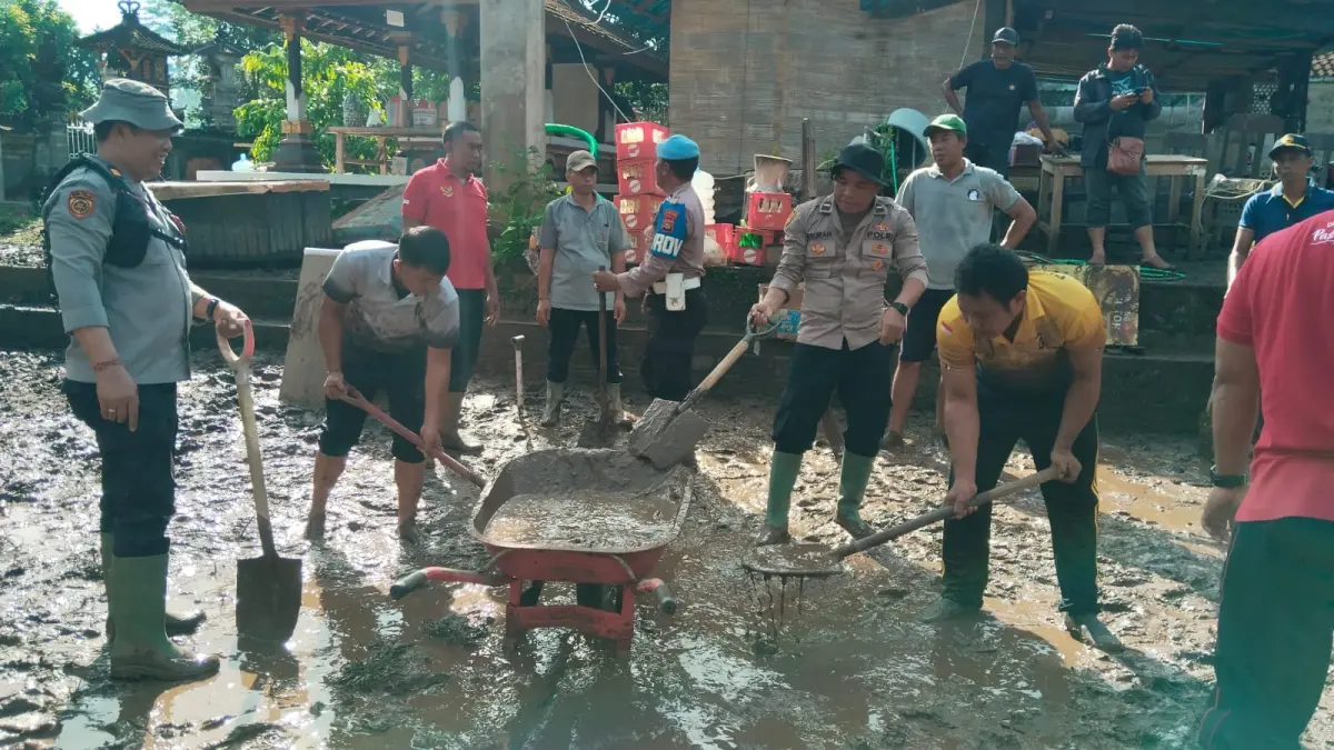 Anggota Polsek Mendoyo bersama BPBD Jembrana dan warga bergotong royong membersihkan lumpur pascabanjir di Tegalcangkring, Jembrana, Senin (6/4/2026). (istimewa)