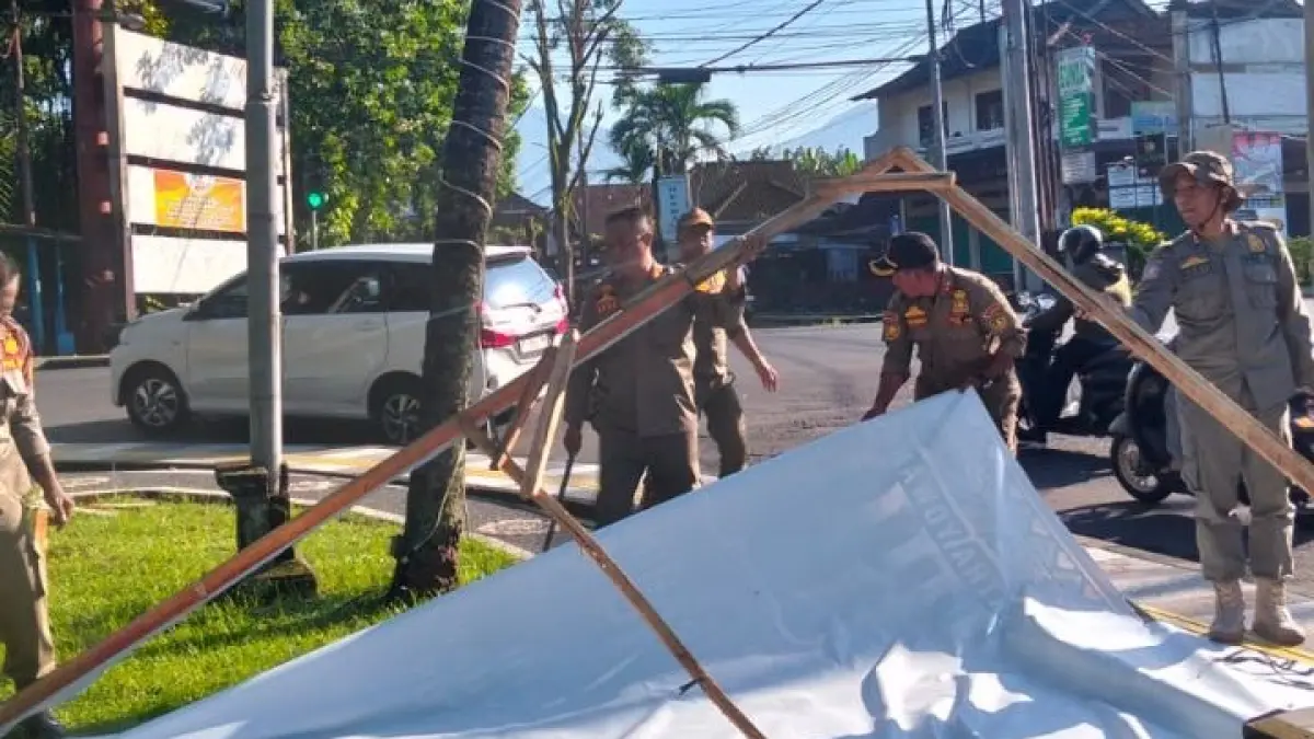 Petugas Satpol PP saat melakukan penertiban reklame di sepanjang Jalan Denpasar–Gilimanuk, wilayah Kecamatan Jembrana hingga Negara, Selasa (7/4). (ist)