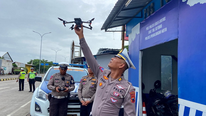 TERBANGKAN - Anggota ar Subdit Gakkum Direktorat Lalu Lintas Polda jateng terbangkan E TLE Drone di simpang exit tol Setono Kota Pekalongan, Jumat (1/12/2023).