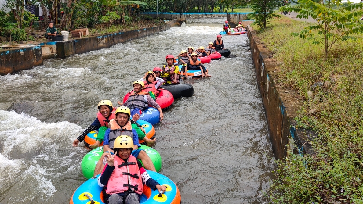 SERU: Pengunjung menikmati susur sungai dengan ban menyisir persawahan. (Riyan Fadli Jawa Pos Metro Pekalongan)