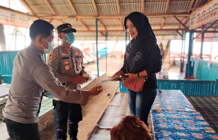 BAGIKAN MASKER ; Anggota polisi Polres Pemalang membagikan masker kepada pengunjung wisata Kamis (21/12/2023).