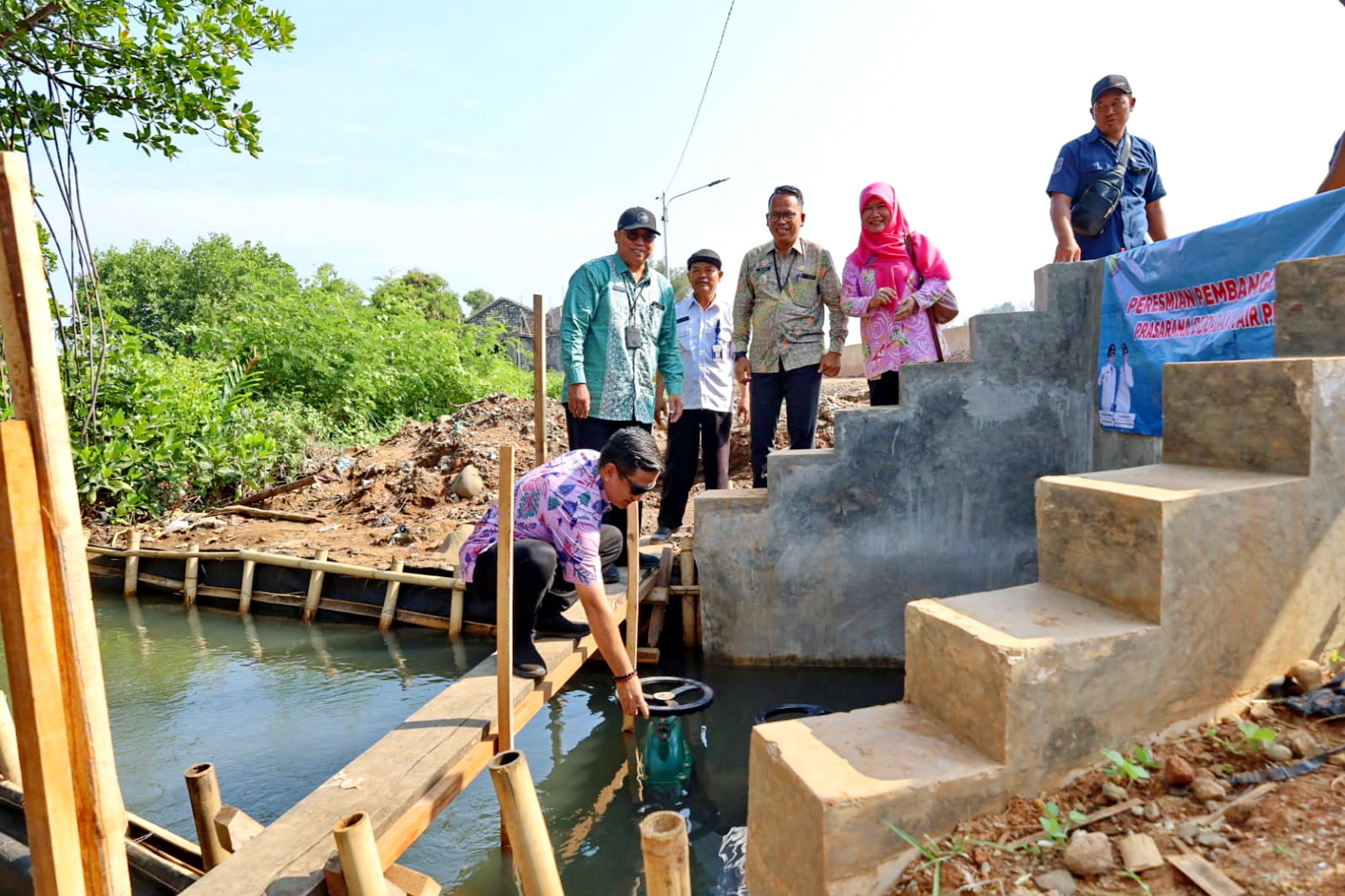 PENYERAHAN SIMBOLIS : Wali Kota Pekalongan HA Afzan Arslan Djunaid memutar pintu air tanda saat penyerahan bantuan akses air payau di Krapyak Pekalongan Utara, Kamis (21/12/2023).
