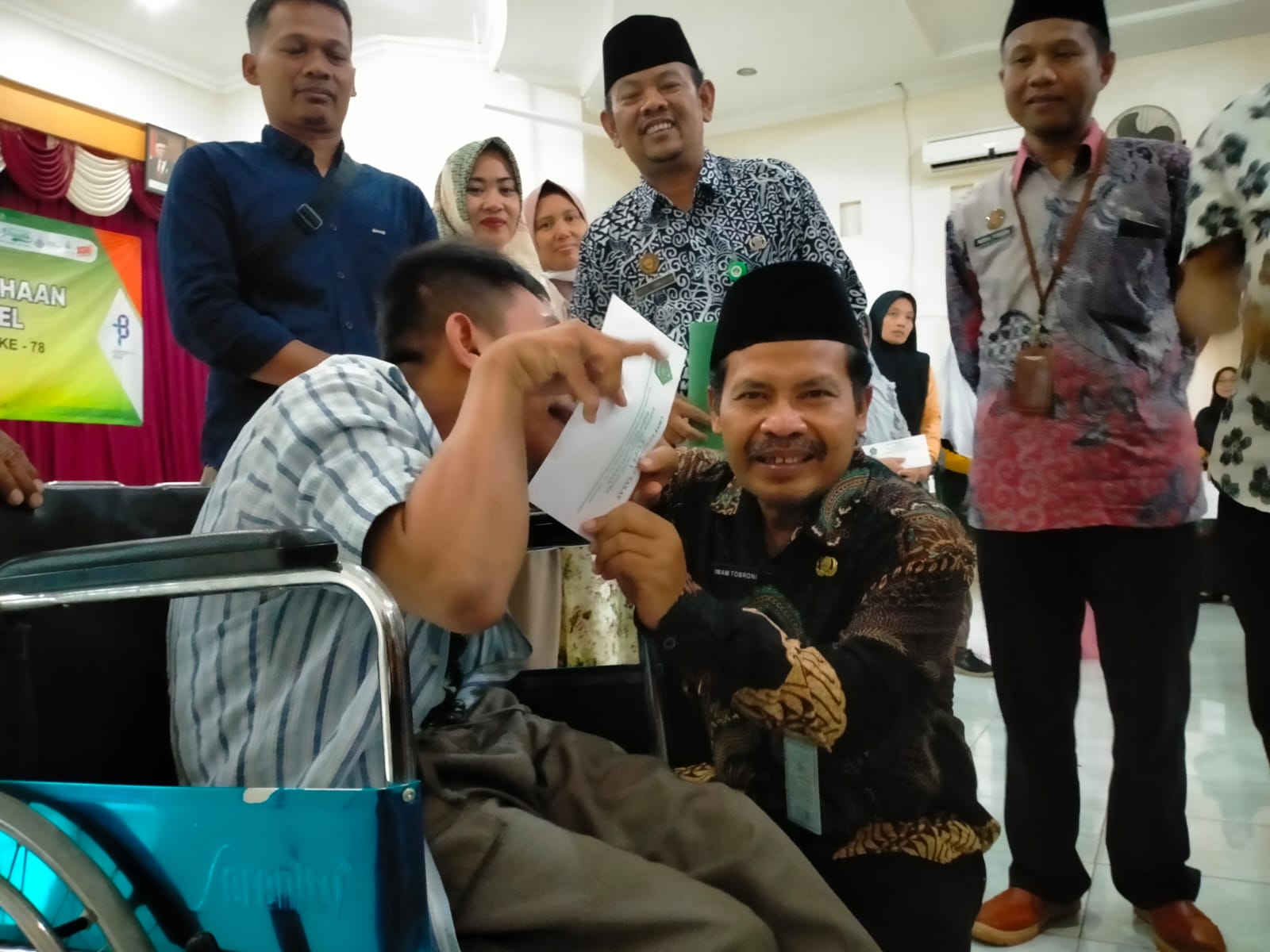 HANGAT: Kepala Kemenag Kabupaten Pekalongan Imam Tobroni saat menyerahkan bantuan untuk salah satu penyandang disabilitas.