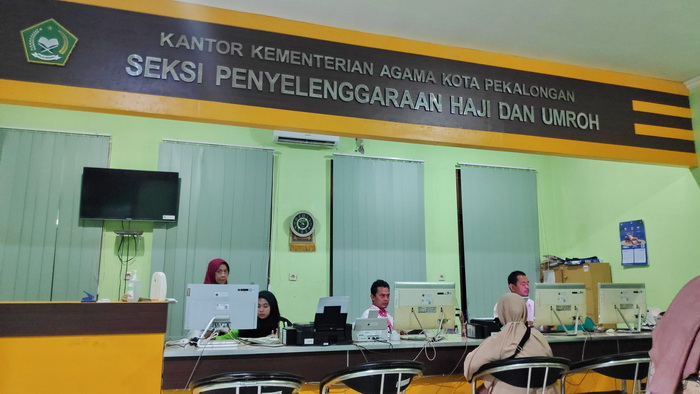 LAYANAN HAJI : Pegawai Kemenag Kota Pekalongan saat memberikan pelayanan kepada masyarakat yang melakukan konsultasi haji .