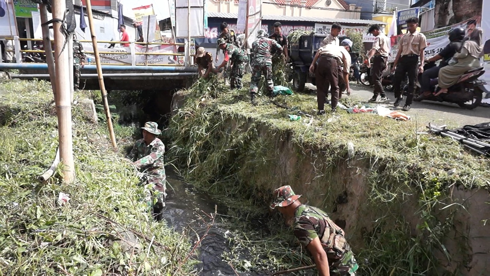 BERJIBAKU: TNI bersama warga saat berjibaku membersihkan saluran air di sekitaran Pasar Kedungwuni, Kabupaten Pekalongan, Jumat (12/1/2024).