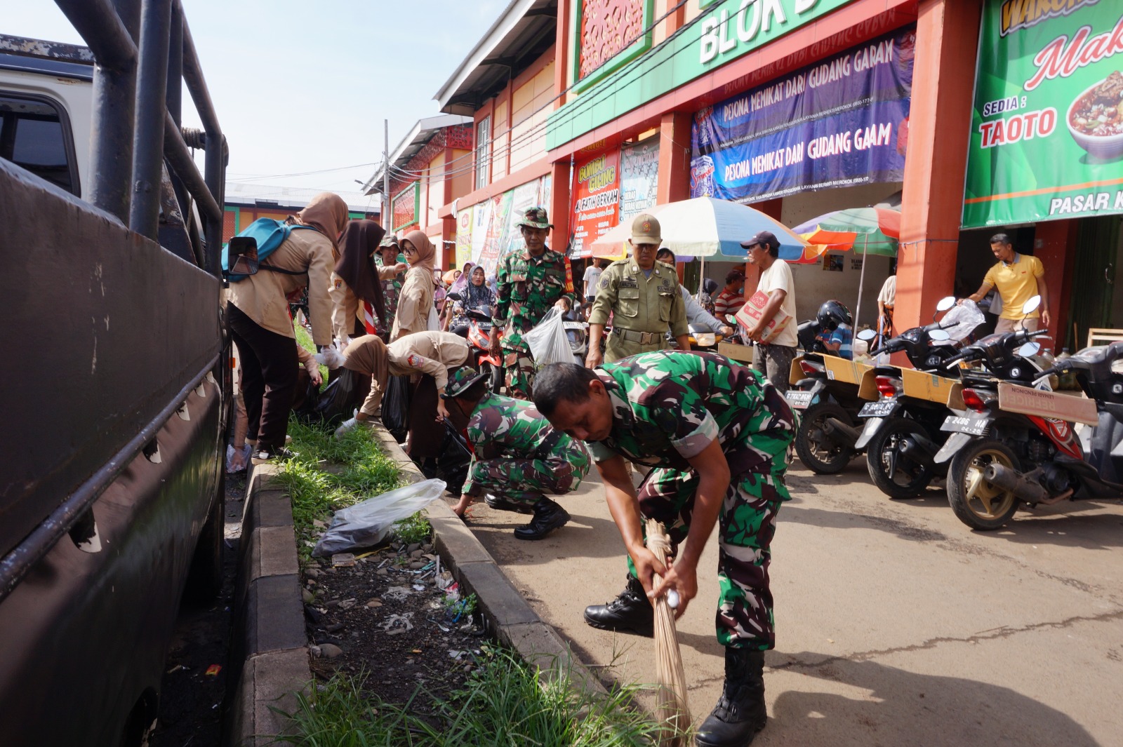 PERANGI SAMPAH: Prajurit TNI dari Kodim 0710/Pekalongan dan Korem 071/Wijayakusuma saat aksi bersih-bersih di Pasar Kedungwuni, Jumat (12/1/2024).