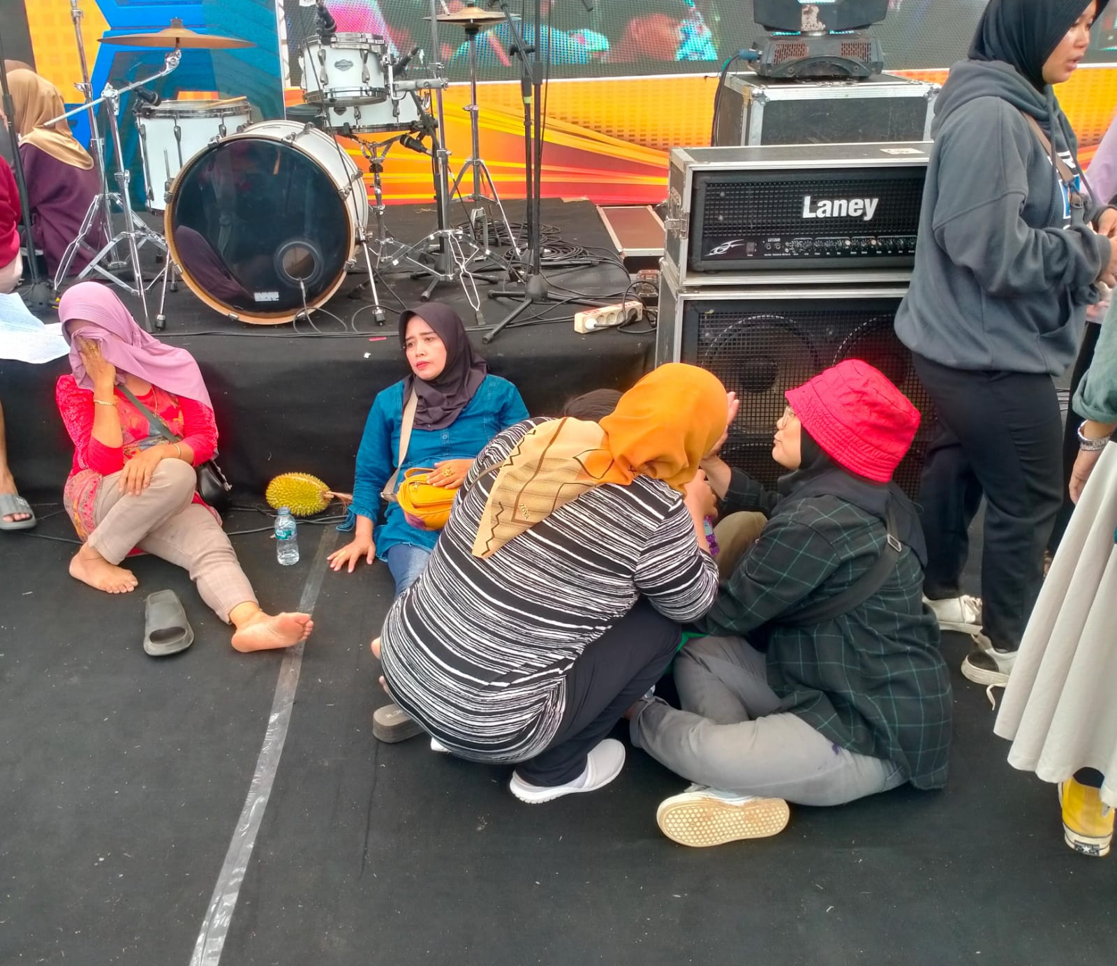 PINGSAN: Sejumlah pengunjung yang diangkut ke atas panggung karena pingsan usai berdesakan berebut durian di acara Festival Durian 2024, Alun-Alun Kajen, Kabupaten Pekalongan, Minggu (12/1/2024).