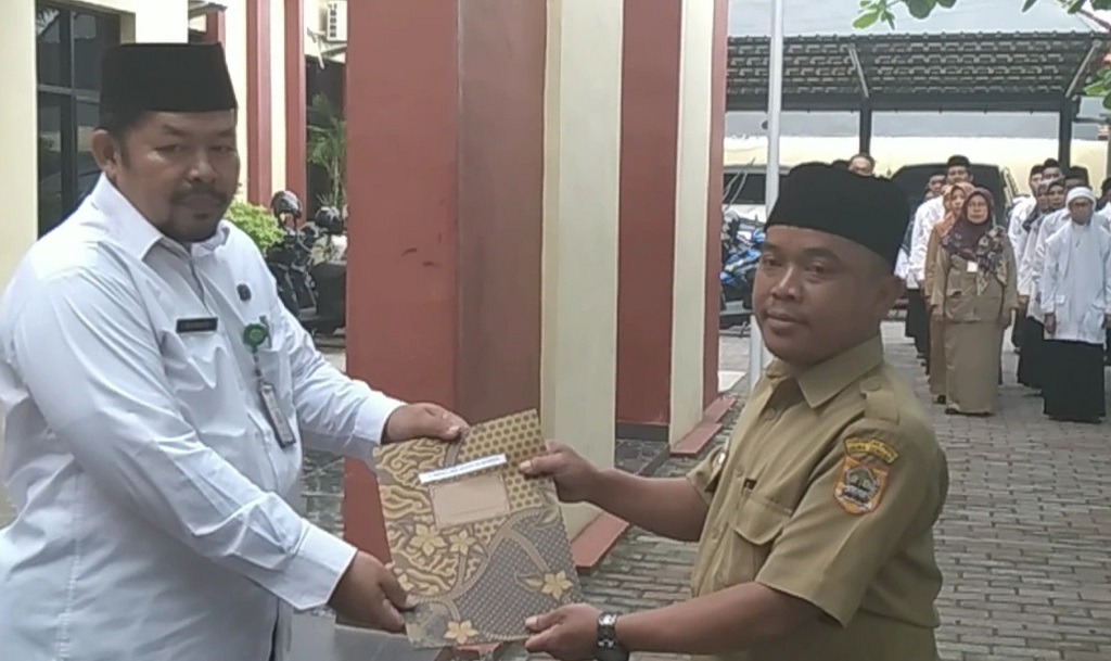 HALAL: Anggota Satgas Halal Penyelenggara Zakat dan Wakaf (Garazawa), Siswoyo saat memberikan sertifikat halal pada salah satu di perwakilan sekolah. (istimwa)
