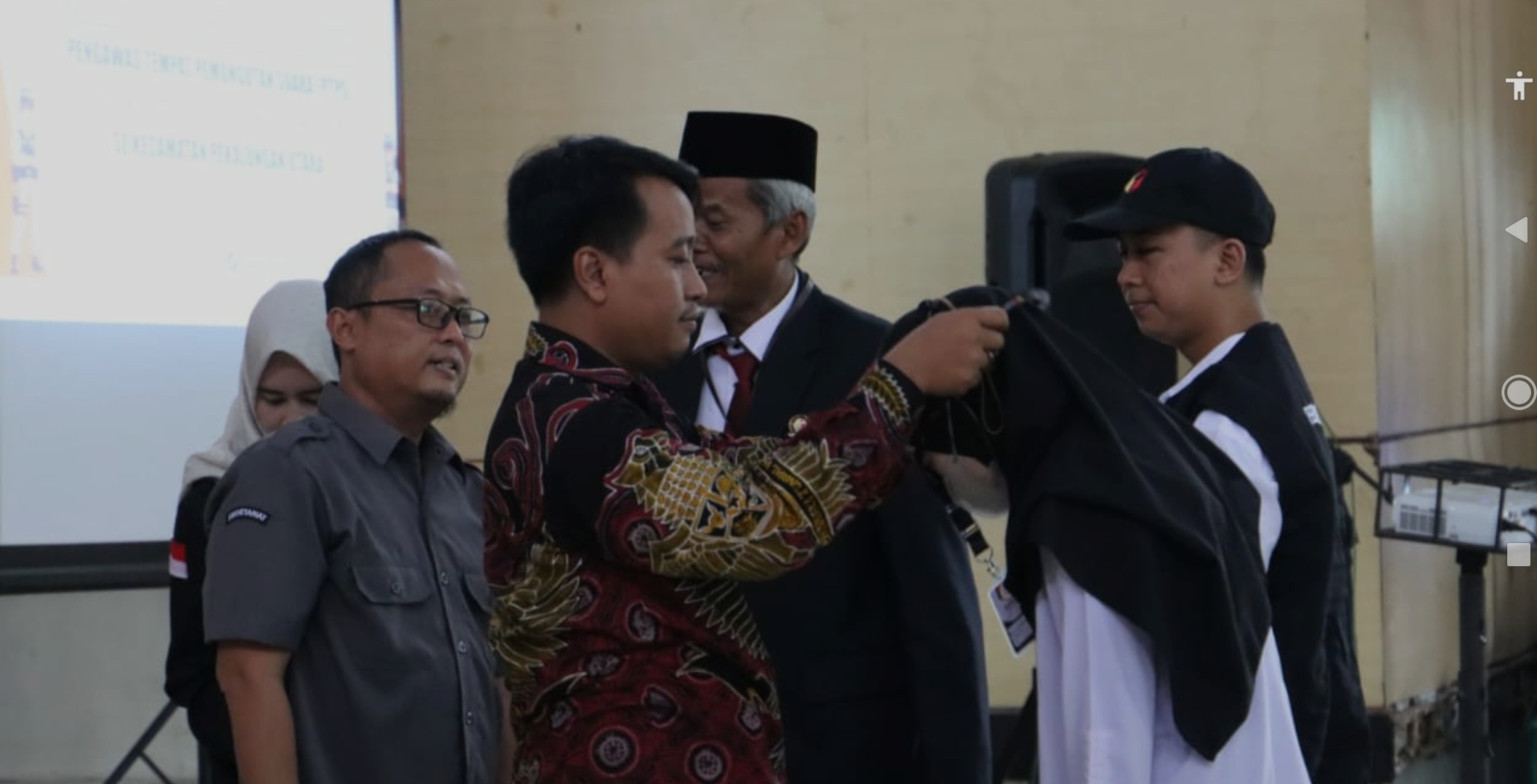 SIMBOLIS - Ketua Bawaslu Kota Pekalongan Miftahudin mengalungkan identitas secara simbolis kepada perwakilan PTPS, pada Senin (22/1/2024).