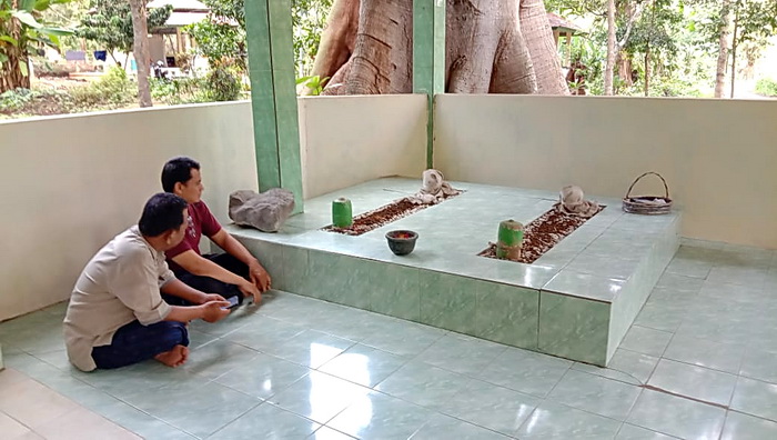 ZIARAH : Ketua Pengurus Makam, Chaerudin (kaos merah) menemani seorang peziarah dari Wonogiri di makam Demang Mertoyudho alias Demang Sulang di desa Kutosari Gringsing.