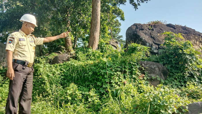 TUNJUKKAN LOKASI : Petugas keamanan&nbsp;pabrik pakan ternak menunjukkan lokasi&nbsp;Watu Rumpuk di dekat bangunan pabriknya, yang konon&nbsp;tidak bisa dipindahkan.