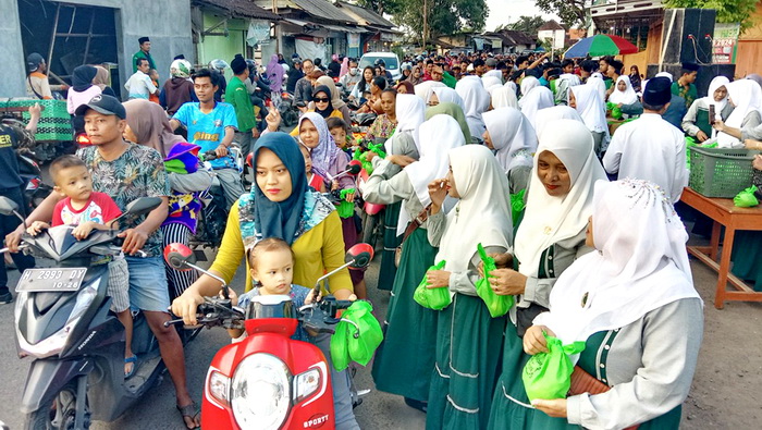 BAGI TAKJIL : Anggota Fatayat Muslimat NU Gringsing saat bagikan 1.500 paket takjil di jalan raya lama Gringsing di depan Ponpes Al Munawwir, Kamis 21 Maret 2024.