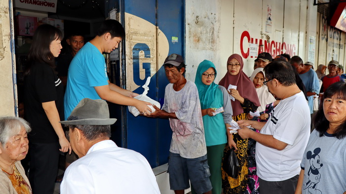 BAGIKAN SEMBAKO: Pemilik toko elektronik Berkah Jaya saat bagikan sembako kepada warga yang kurang mampu, Sabtu (6/5/2024).