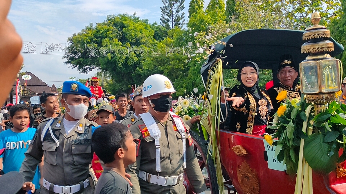 SAWUR: Pj Bupati Batang Lani Dwi Rejeki saat melakukan sawur uang receh kepada masyarakat dalam Kirab Budaya peringatan HUT Kabupaten Batang ke-57 tahun lalu. (Riyan Fadli Jawa Pos Metro Pekalongan)