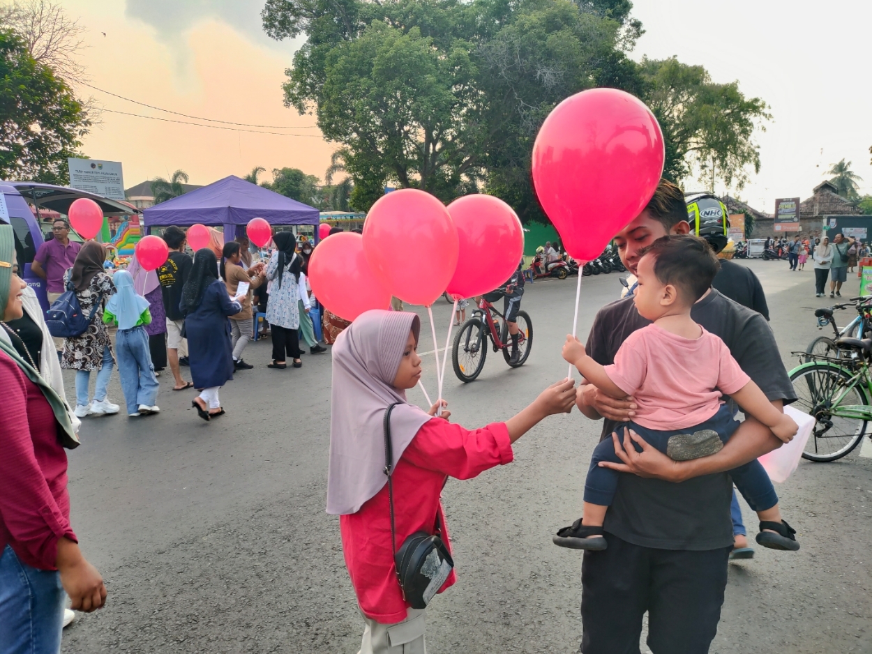 TERIMAKASIH: Para penyandang talasemia sedang bagi-bagi balon merah di Alun-Alun Batang. (Riyan Fadli Jawa Pos Metro Pekalongan)