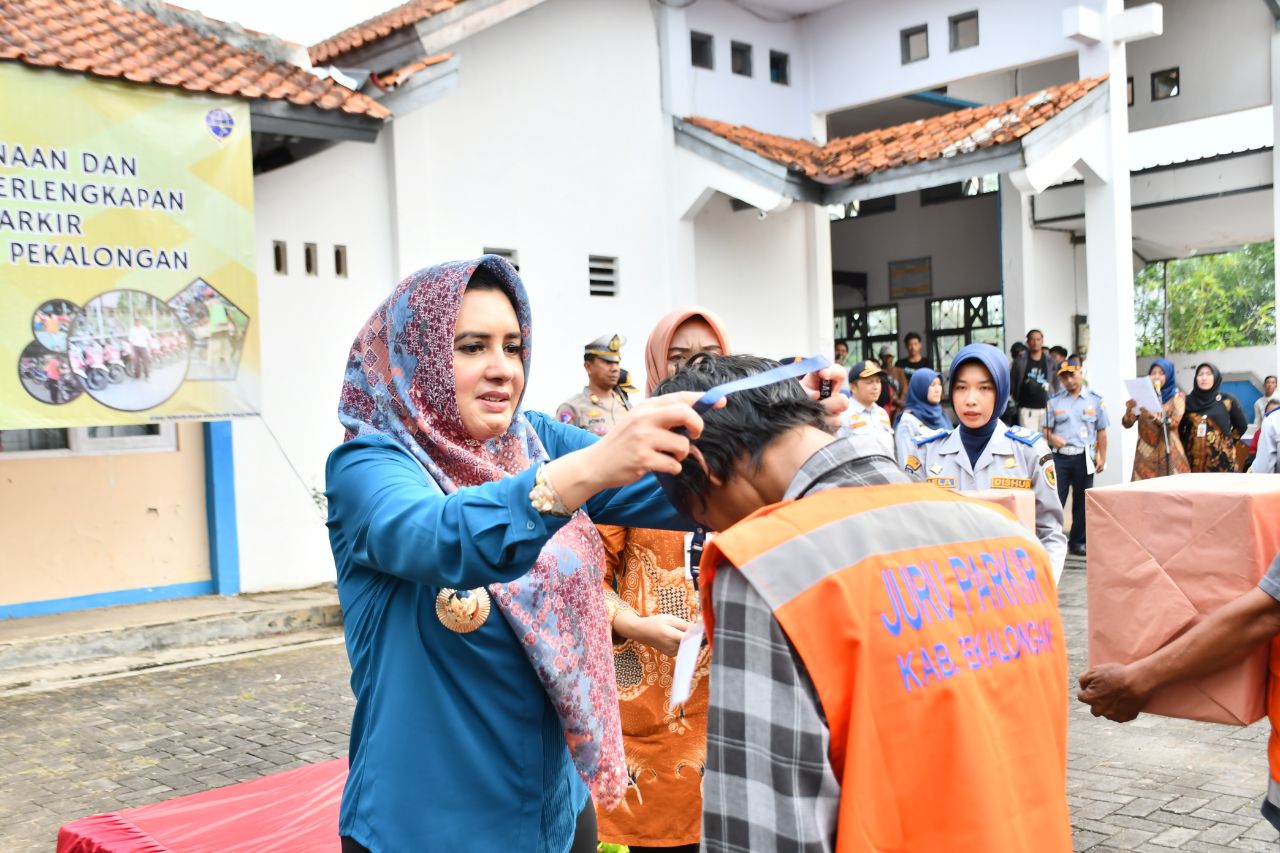 SIMBOLIS: Bupati Pekalongan Fadia Arafiq secara simbolis menyematkan topi kepada salah satu jukir saat acara apel pembinaan dan penyerahan perlengkapan jukir se-Kabupaten Pekalongan.