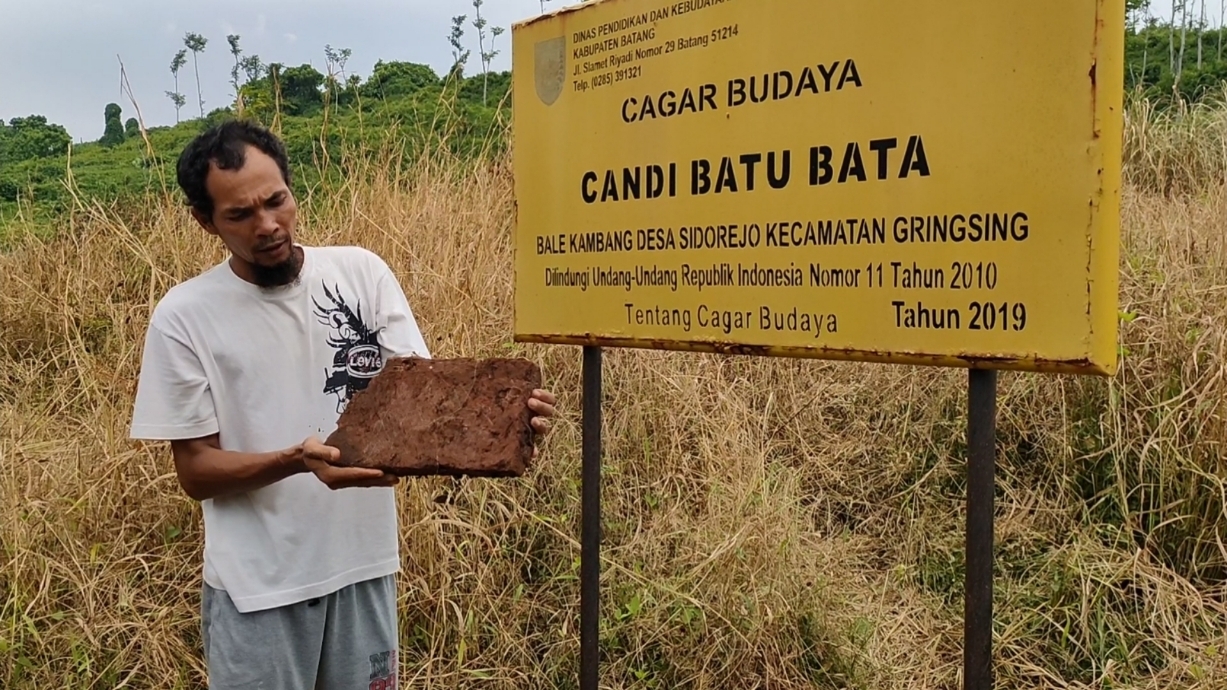 PENUH SEMAK: Seorang warga menunjukkan batuan candi batu bata merah di Desa Sawangan Kecamatan Gringsing beberapa waktu lalu. (Riyan Fadli Jawa Pos Metro Pekalongan)