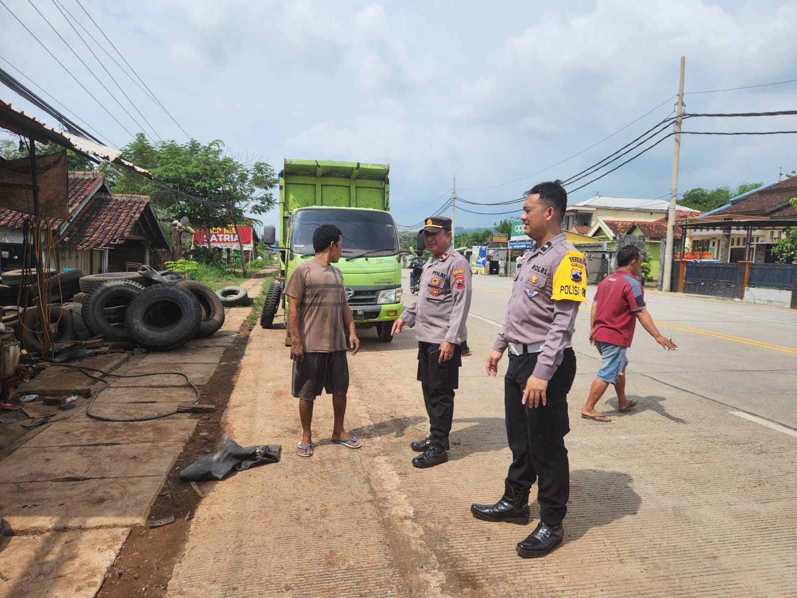 TERTIBKAN: Anggota Polsek Gringsing saat menertibkan lapak tambal ban yang ersahkan warga, karena menutup badan jalan, Kamis siang (13/6/2024).