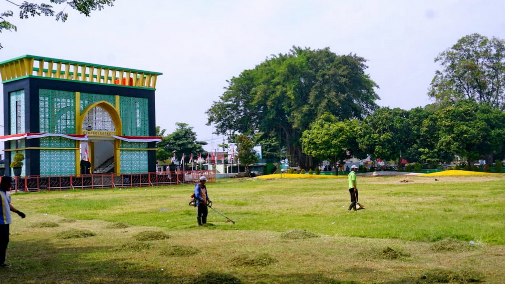 DIRAPIKAN: Petugas dari DLH Kota Pekalongan yang merapikan rumput di Kawasan Alun-alun Kota Pekalongan, Jumat (9/8/2024).