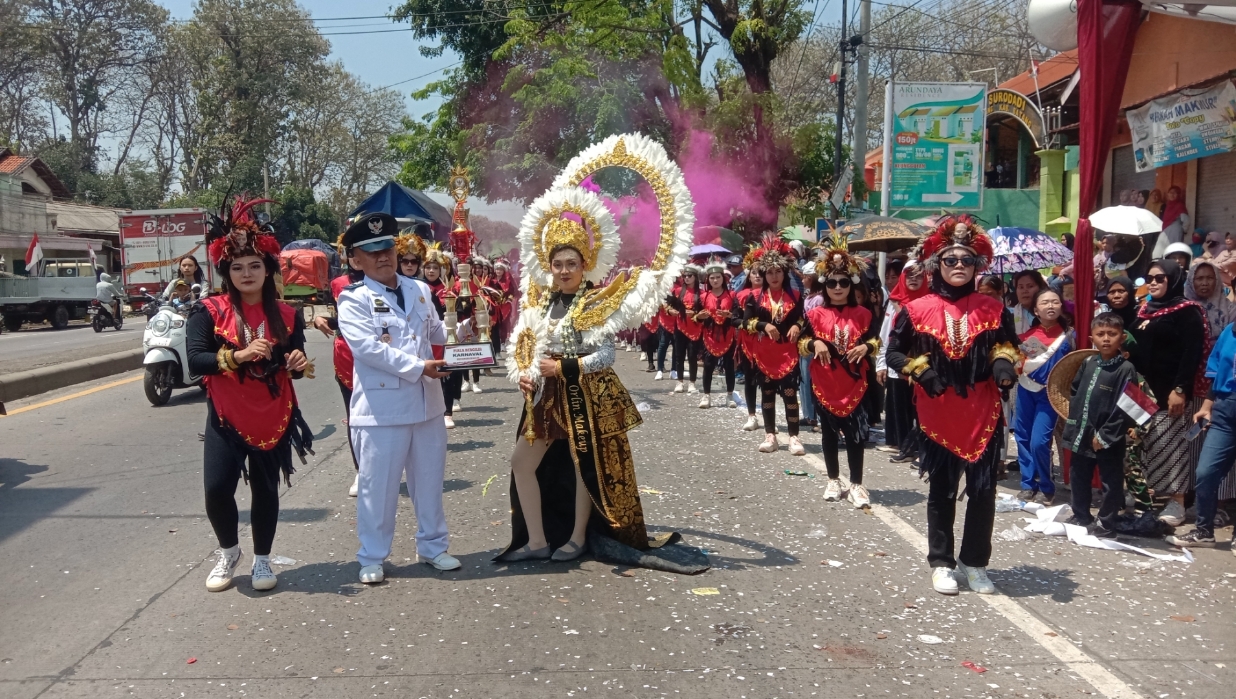 PIALA BERGILIR: Kades Surodadi Muhlisin membawa piala bergilir yang diperebutkan peserta karnaval desa Surodadi.