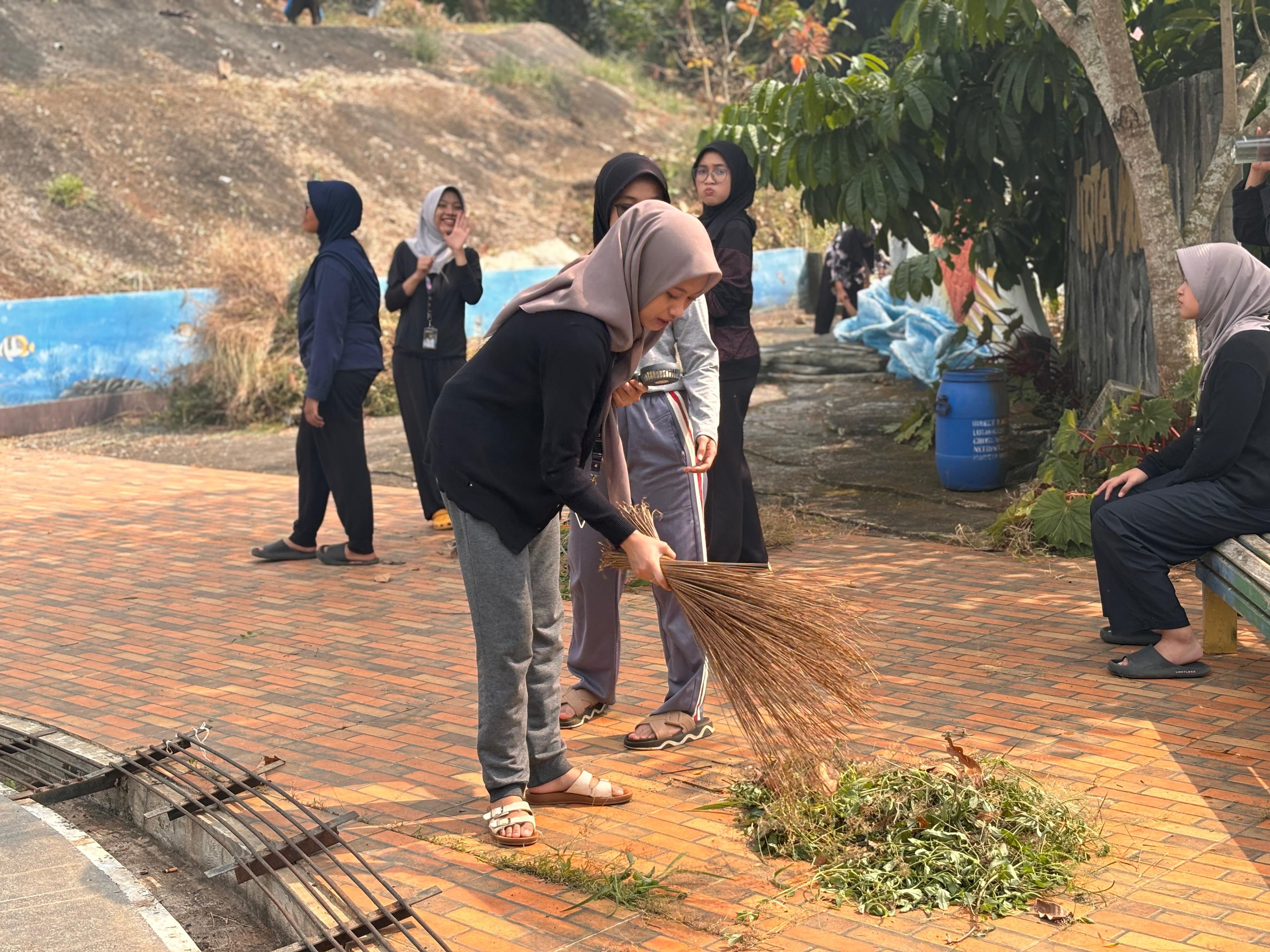 BERSIHKAN: Mahasiswa KKN UNS saat bersihkan kawasan playground dan aula Curug Gombog di Pecalungan Batang.