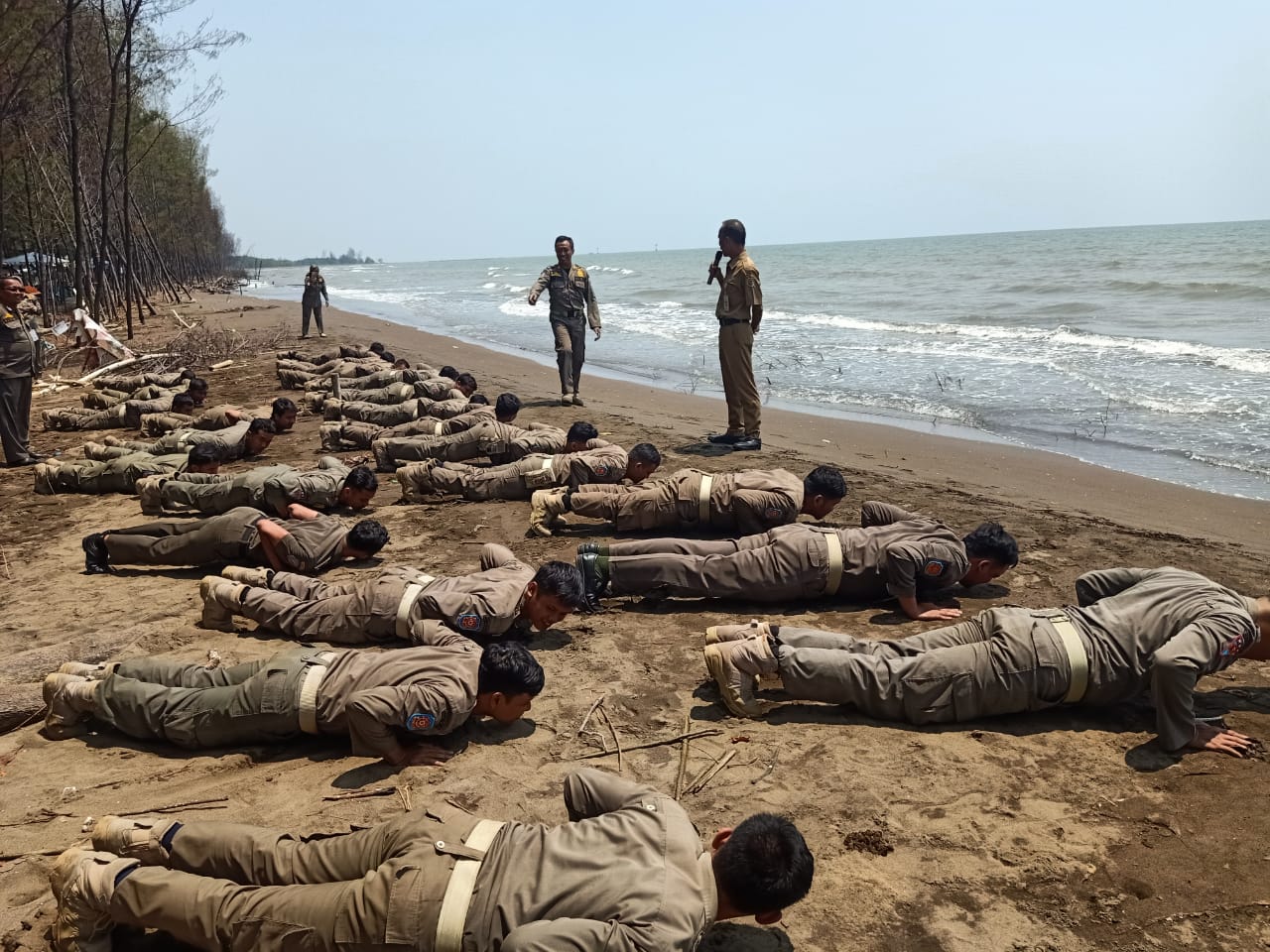DIGEMBLENG: Personel Satpol-PP Kabupaten Pekalongan saat digembleng pelatihan bintal di Pantai Wonokerto, Senin (2/8/2024).