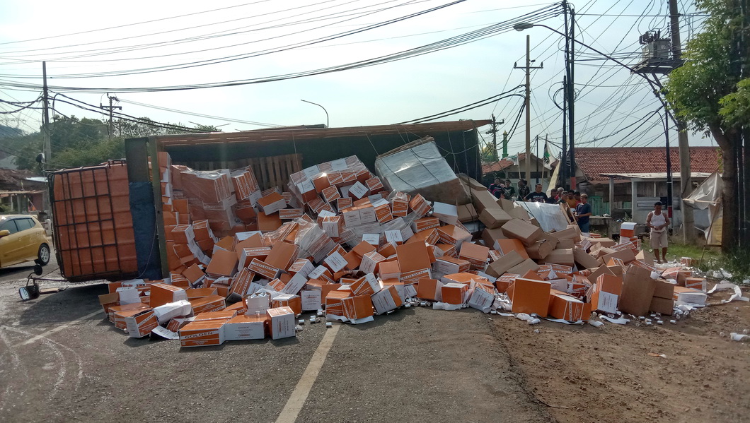 BERSERAKAN: Truk bermuatan kertas terguling, menumpahkan isinya ke jalan raya Pantura Desa Plelen Rabu (03/10/2024).
