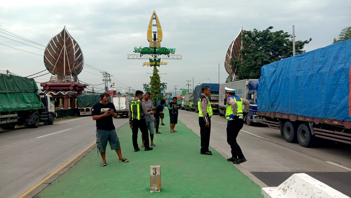 MENUMPUK : Ratusan truk dan kendaraan besar menumpuk di jalan raya Pantura Gringsing karena dilarang melintasi tol dan lingkar Weleri, Minggu (22/12/2024).