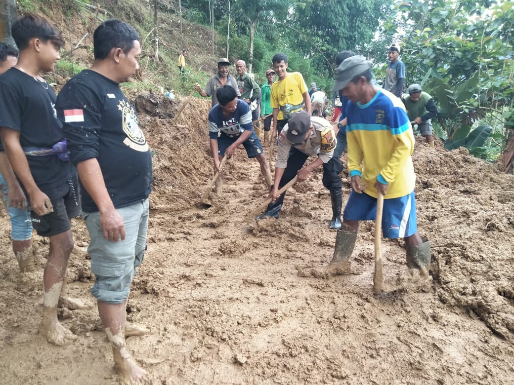 LONGSOR: Gotong royong warga bersama polisi dan TNI membersihkan material longsor di jalan utama Kandangserang, Kabupaten Pekalongan, Senin (20/1/2025).