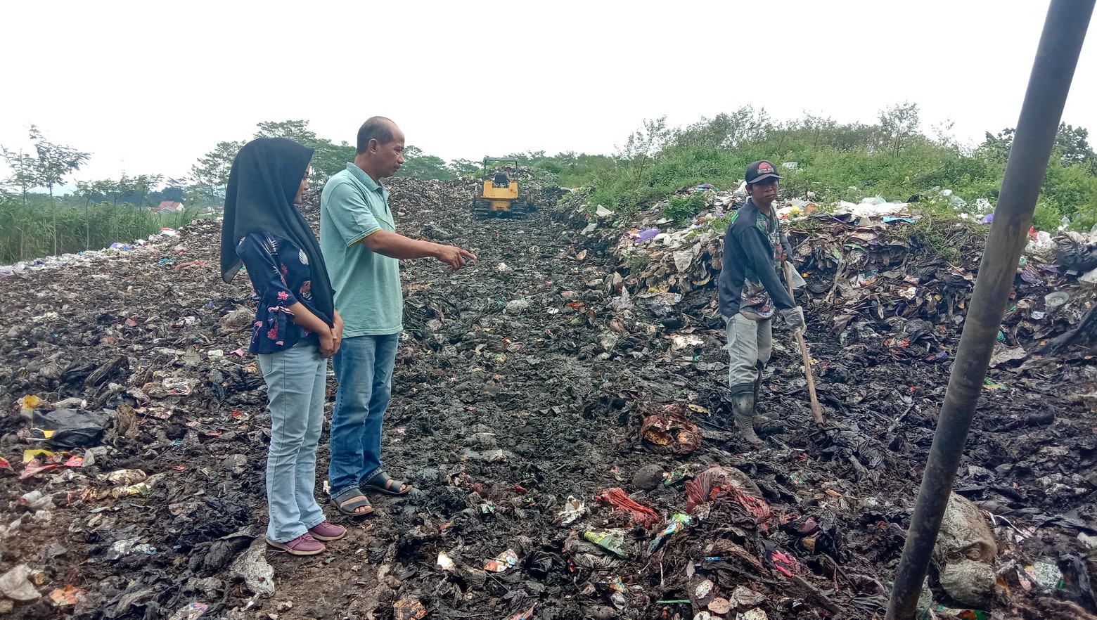 GUNUNG SAMPAH: Kepala Pasar Limpung dan pasar Plelen Indi Harto menunjukkan lokasi penampungan sampah di pasar Limpung yang semakin menumpuk, Minggu (23/02/2025).