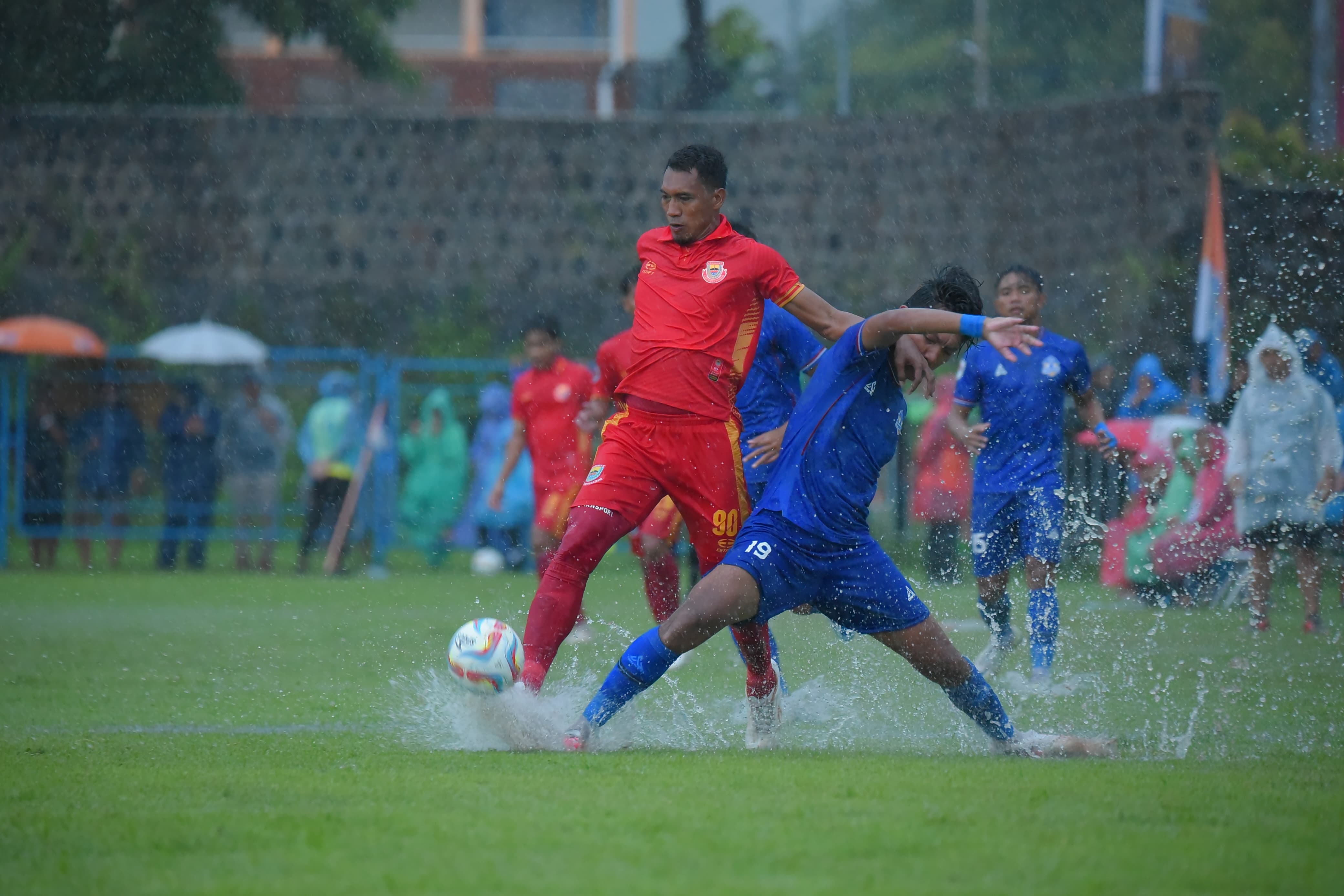 LAGA BERLANJUT: Pemain Persibat berjibaku di kubangan air saat berhadapan dengan Persika di Karanganyar sebelum laga dihentikan.
