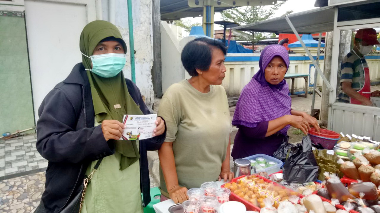 TUNJUKKAN STIKER - Tim Pengawas makanan DInkes Kota Pekalongan menunjukkan stiker makanan aman, di salah satu lapak penjual makanan di wilayah setempat.