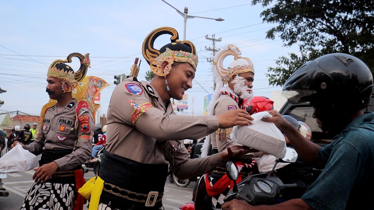BAGI TAKJIL - Sambil kenakan kostum wayang Orang, sejumlah anggota Polres Pemalang bagikan Takjil di Simpang Sirandu Pemalang, Rabu (5/4/2025).