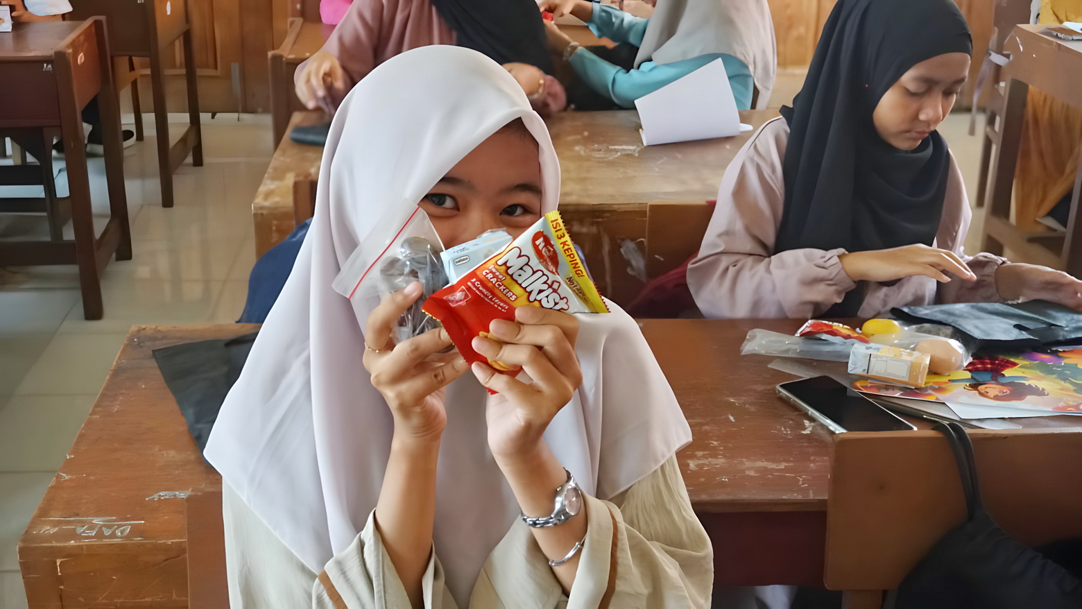 TUNJUKKAN - Salah satu siswi menunjukkan menu MGB yang sudah diterimanya, sudah di bagi di sekolahnya.