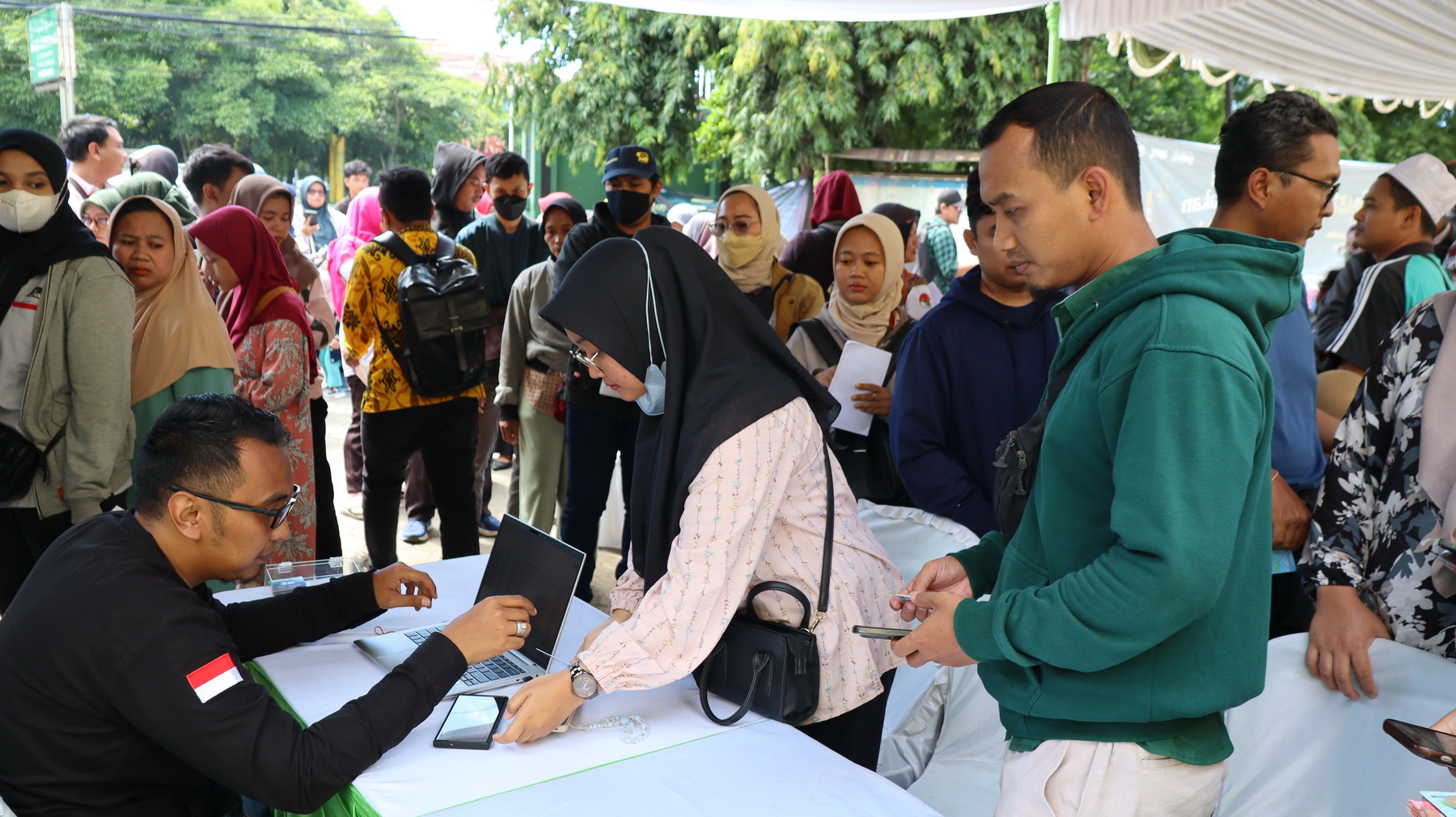 CEK PENDAFTARAN - Tim dari KPw BI Tegal saat mengecek pendaftaran warga di aplikasi pintar, untuk tukar uang, di halaman Masjid Asy-Syuhada, Kota Pekalongan, pada Selasa siang (11/3/2025)