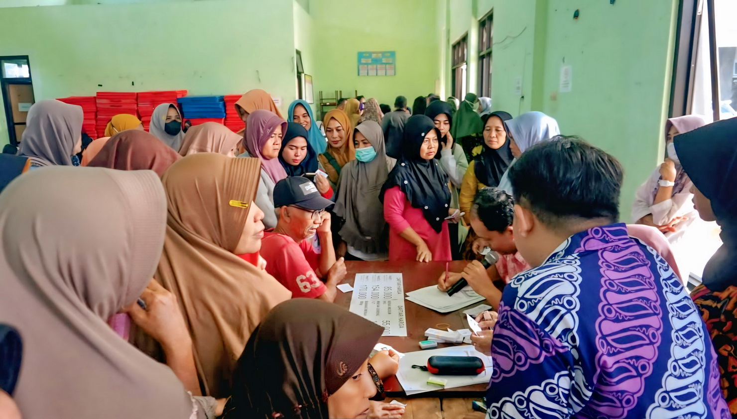 ANTRI - Warga saat antri mendaftar, agar bisa membeli kepokmas dengan harga subsidi dari pemerintah, di&nbsp;&nbsp;di Aula Kecamatan Pekalongan Barat pada Kamis (13/3/2025).