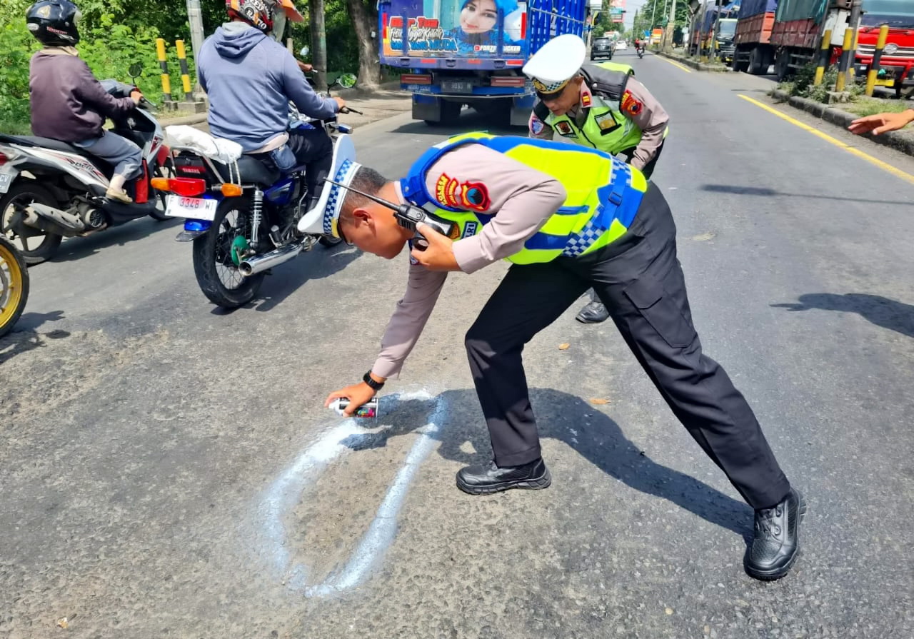 TANDAI - Anggota Satlantas Polres Pekalongan Kota saat menandai lobang di jalan pantura Kota Pekalongan, agar diperhatikan pengendara dan segera ditambal.