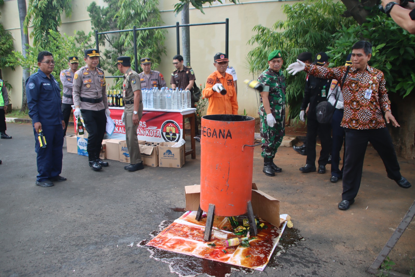 MUSNAHKAN MIRAS - Fokompimda Kota Pekalongan dan jajaran, turut serta memusnkan miras di Halaman Mapolres Pekalongan Kota, Jumat sore (21/3/2025).